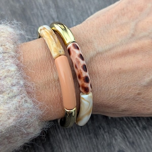 Bracciale rigido con perline tubolari marmorizzate leopardate nei colori beige, marrone e oro