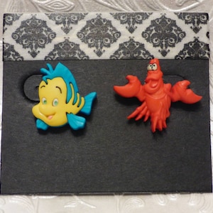 Linguado e Sebastião dos Brincos da Pequena Sereia da Disney