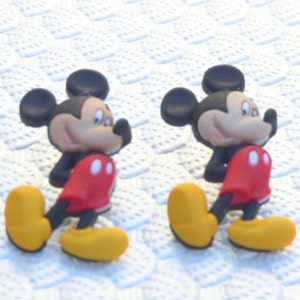 Może przedstawiać: Dwie czerwono-czarne postacie kresk&oacute;wkowego Myszki Miki w ż&oacute;łtych butach. Figurki stoją na białym tle.