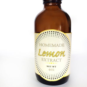 May include: A brown glass bottle with a black lid and a white label that says "HOMEMADE Lemon EXTRACT NET WT 4 oz".