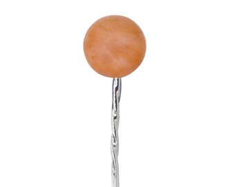 May include: A peach-colored glass bead on a silver pin.