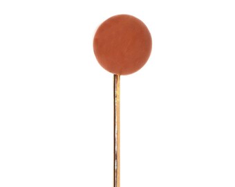 May include: A terracotta colored round pin head on a gold pin.