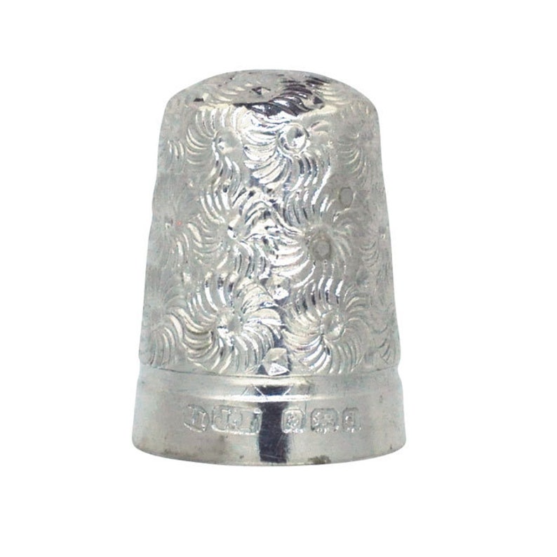 May include: A silver thimble with a floral pattern and the inscription "925" on the bottom.