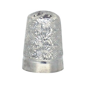 May include: A silver thimble with a floral pattern.
