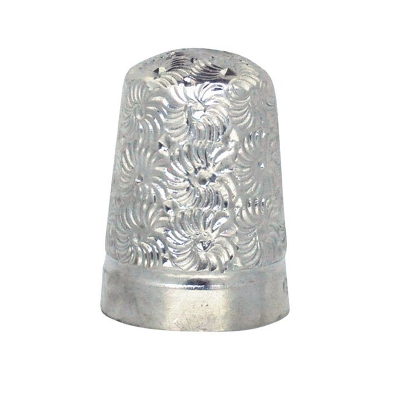 May include: A silver thimble with a floral pattern.