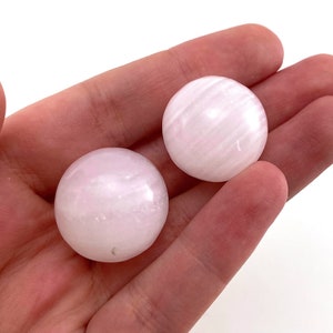 May include: Two smooth, white selenite spheres with a striated pattern. The spheres are approximately 2 inches in diameter.