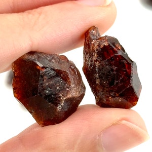 May include: Two brown and red, faceted, rough, natural, gemstone crystals.
