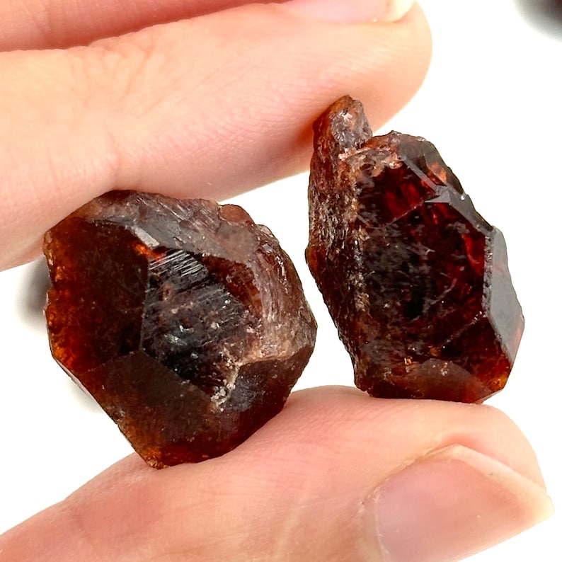 May include: Two brown and red, faceted, rough, natural, gemstone crystals.