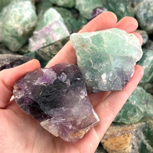 K&ouml;nnte beinhalten: Zwei gro&szlig;e St&uuml;cke Fluoritkristalle. Eines ist tiefgr&uuml;n, das andere ist eine Mischung aus Lila, Gr&uuml;n und Schwarz.