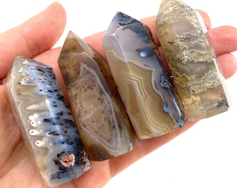 May include: Four agate crystal points with brown, white, and gray banding. The points are polished and have a smooth, glassy finish.