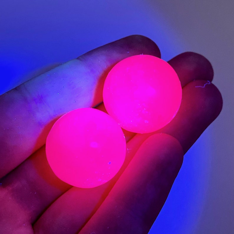 May include: Two bright pink glow-in-the-dark balls.