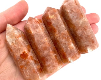 May include: Five sunstone points, also known as golden healer crystals, in various shades of orange and brown. The points are smooth and polished, with a natural, raw look.