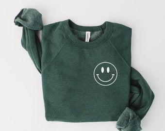 May include: A dark green sweatshirt with a white smiley face graphic on the front.