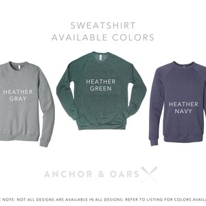 May include: Three sweatshirts in different colors: heather gray, heather green, and heather navy. The text "SWEATSHIRT AVAILABLE COLORS" is at the top of the image. The text "ANCHOR & OARS" is at the bottom of the image.