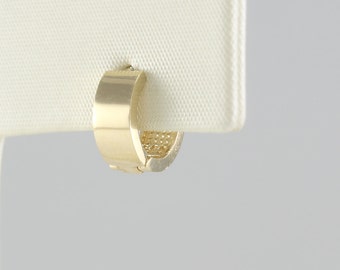May include: A pair of gold hoop earrings. The earrings are small and have a simple design.