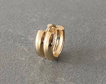 May include: A gold hoop earring with a double-layered design.