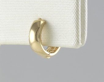 May include: A gold hoop earring with a smooth, rounded surface.