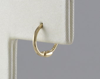 May include: A gold hoop earring with a smooth finish.