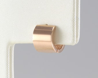 May include: A rose gold hoop earring with a smooth, polished finish.