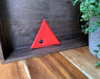 Leather triangle coin purse made of thick red leather.