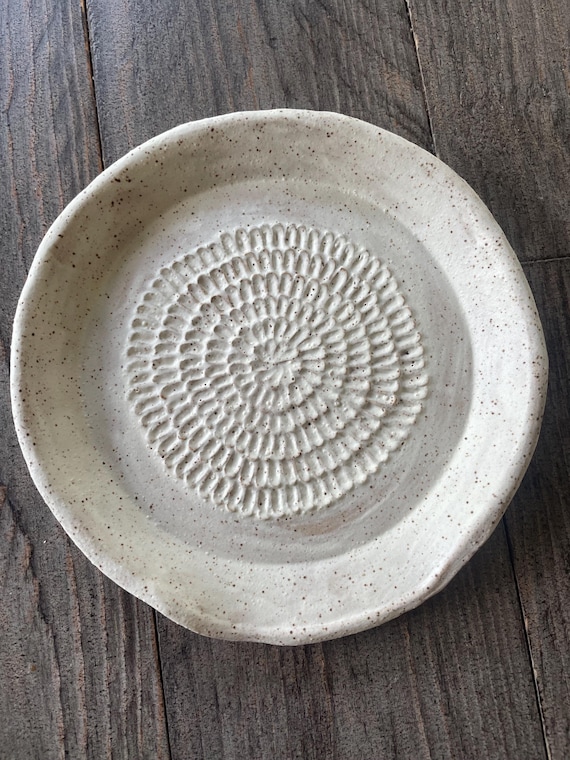 A 2-in-1 ceramic spoon rest with a built-in garlic and ginger grater — genuinely clever dual-function design that most kitchens don't have.