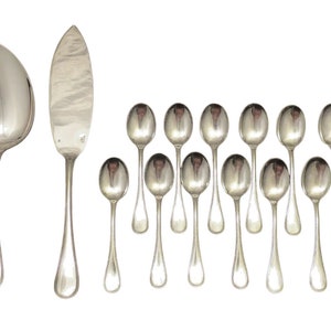 Può includere: Un set di posate d'argento, tra cui un cucchiaio da portata, un coltello per torta e 12 cucchiaini. Le posate sono disposte in fila su uno sfondo bianco.