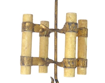 May include: A gold metal candle holder with five candle slots. The candle holder is designed to hang from the ceiling and has a hook at the top. The candle holder is made of metal and has a rustic finish.