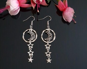 May include: Silver dangle earrings with a crescent moon charm and a chain of stars hanging from a circle.