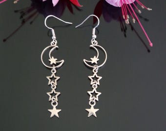 May include: Silver dangle earrings with a crescent moon charm and five star charms hanging below. The earrings have a simple hook closure.