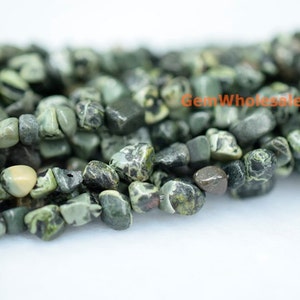 May include: A strand of green and black patterned stone beads. The beads are irregularly shaped and have a tumbled finish.