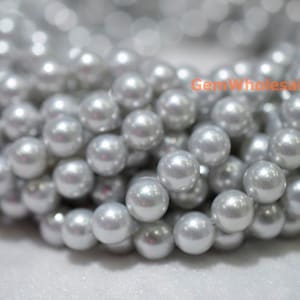 Peut inclure: Un brin de perles rondes et lisses de couleur argentée. Les perles ont un léger reflet irisé.