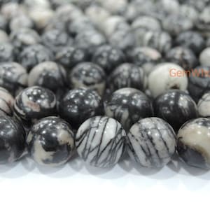 Puede incluir: Una hebra de cuentas de jaspe cebra negro y blanco. Las cuentas son redondas y tienen un acabado liso y pulido.