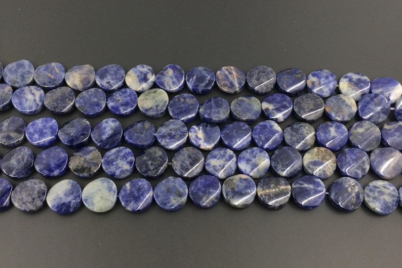 May include: A strand of blue and white oval-shaped gemstone beads. The beads are made of natural sodalite and have a smooth, polished finish.