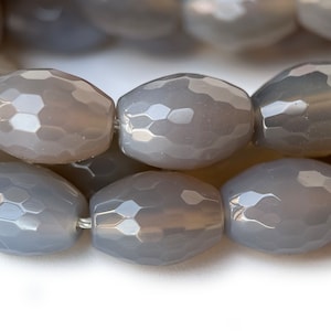 May include: A strand of grey faceted oval beads. The beads have a hexagonal pattern and are strung on a silver wire.