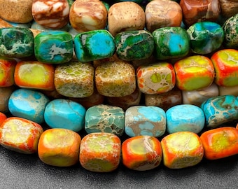 Può includere: Primo piano di una collezione di perline di pietre preziose lucide e colorate. Le perline sono di forma quadrata e presentano una varietà di colori, tra cui turchese, verde, arancione, giallo e marrone. Le perline sono disposte in file.
