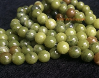 May include: A strand of green jade beads, each bead is round and smooth. The beads are strung on a clear elastic cord. The beads are a light green colour with some darker green streaks.