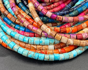 Può includere: Una collezione di perline cilindriche colorate in varie tonalità di blu, arancione, rosa e marrone. Le perline sono infilate insieme, creando un aspetto vibrante e strutturato. Le perline vengono probabilmente utilizzate per la creazione di gioielli o altri progetti artigianali.