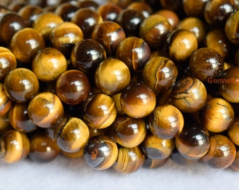 May include: Close-up of a strand of round, golden brown tiger's eye beads. The beads have a shimmering, iridescent quality.