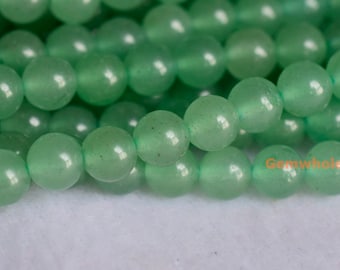 May include: Close-up of strands of light green, round beads. The beads have a smooth, polished surface and appear to be made of a translucent material. The beads are strung together, suggesting they are for jewelry making or crafting.