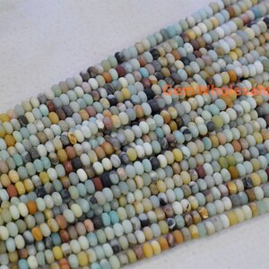 May include: Strands of small, round beads in a variety of colors including beige, brown, gray, and blue-green. The beads are strung together, creating a textured surface. The beads appear to be made of stone or a similar material.