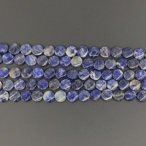 May include: A strand of round, blue and white gemstone beads. The beads are smooth and polished, with a natural, mottled appearance.