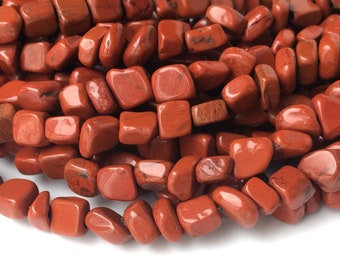 May include: A strand of red jasper gemstone beads, each bead is a tumbled, irregular square shape.