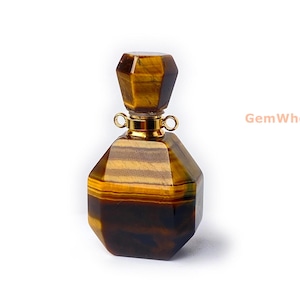 May include: A gold-toned, octagonal-shaped bottle made of tiger's eye gemstone. The bottle has a gold-toned cap and a gold-toned loop on each side of the cap.