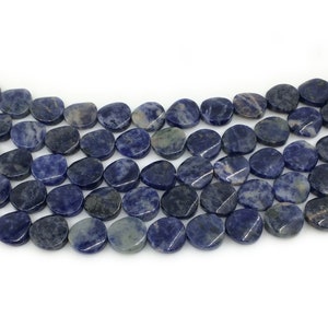 May include: A strand of blue and grey gemstone beads, each bead is a smooth, oval shape.