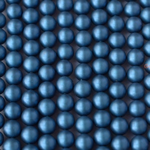 May include: A strand of round, matte blue beads. The beads are uniform in size and have a smooth, slightly iridescent finish.