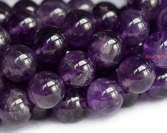 May include: A close-up of a strand of round, purple amethyst beads. The beads are smooth and polished, with a slight shimmer.