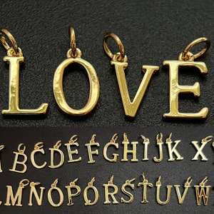 May include: Gold-tone alphabet letter charms, including the letters L, O, V, and E, and the entire alphabet from A to Z. The charms are designed to be used for jewellery making.