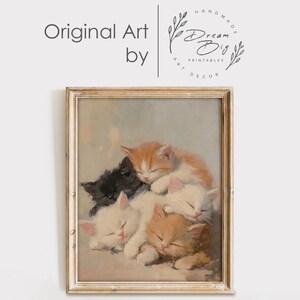 May include: A vintage painting of five kittens sleeping in a pile. The kittens are various shades of white, orange, and black. The painting is framed in a light wood frame.