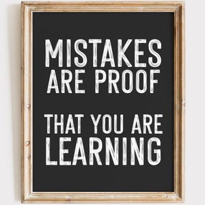 May include: Black and white motivational quote on a framed chalkboard. The quote reads "Mistakes are proof that you are learning."