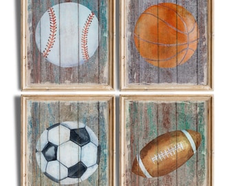 Puede incluir: Conjunto de cuatro impresiones enmarcadas que representan una pelota de béisbol, una pelota de baloncesto, una pelota de fútbol y una pelota de fútbol americano. Cada pelota se representa en un estilo realista sobre un fondo de veta de madera.